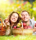 Happy People Eating Organic Apples in Autumn Garden.Healthy Food