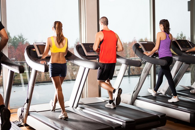 Group of people running on treadmills