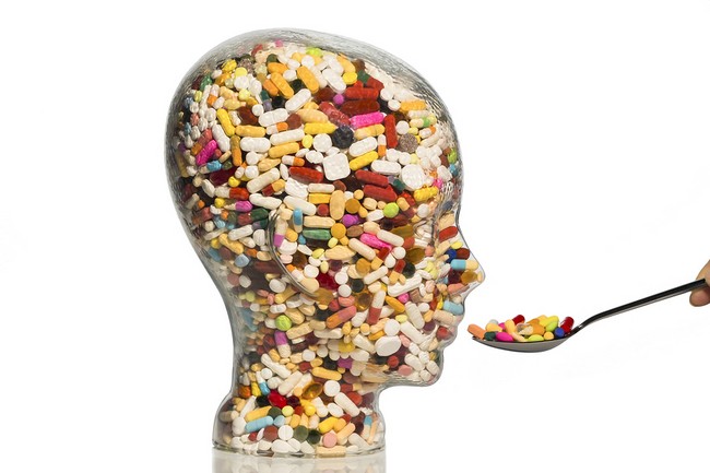 a glass head filled with many tablets. photo icon for drugs