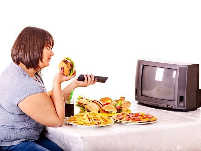 Big woman eating fast food and watching TV. Isolated.