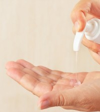 Female hands using antibacterial liquid soap