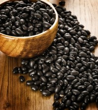 Frijoles, mexican black beans, on wooden background,