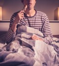 Young Man Is Sitting In Bed And eating Chicken