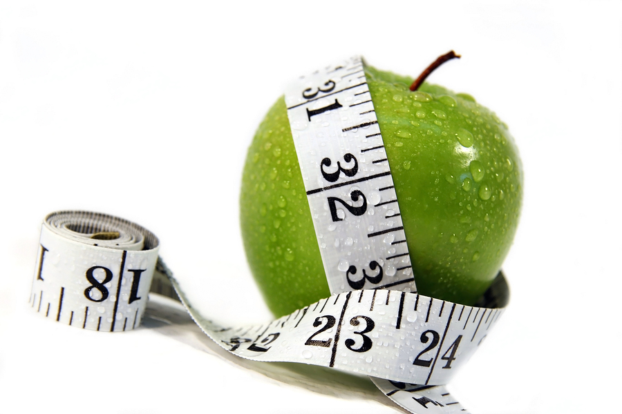 Measurement tape wrapped around green apple/Concept for health, diet